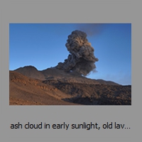 ash cloud in early sunlight, old lavaflows in front